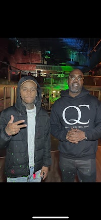 two men standing next to each other at a club